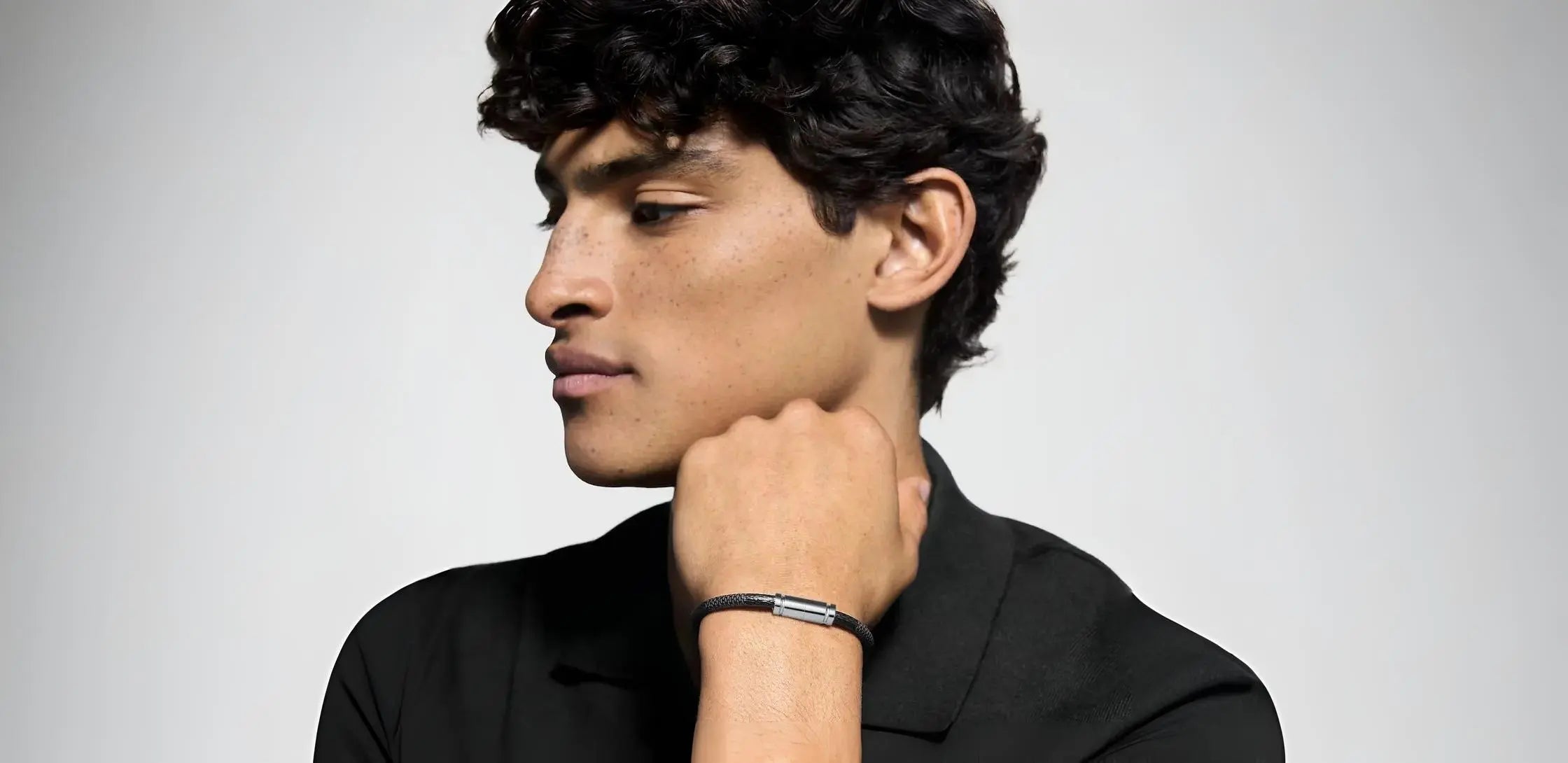 Man wearing a black shirt against a gray background with a Velmont bracelet.