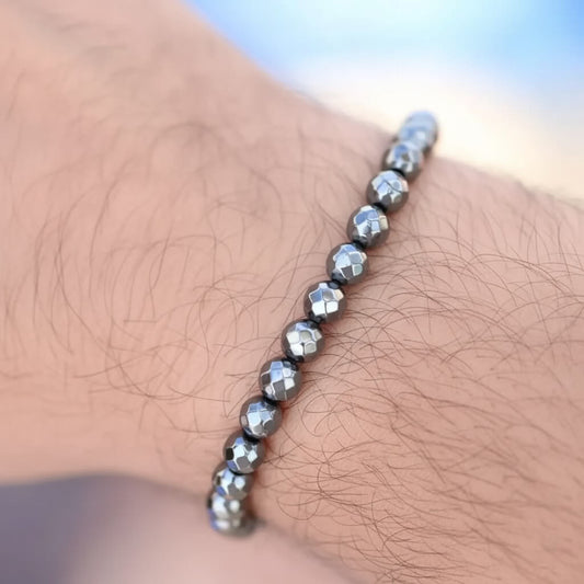 Silver beaded bracelet on a wrist with a blurred background